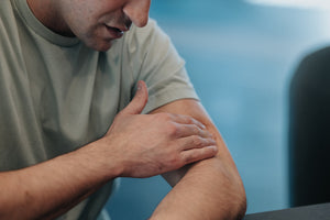 man with pain applying pain cream 